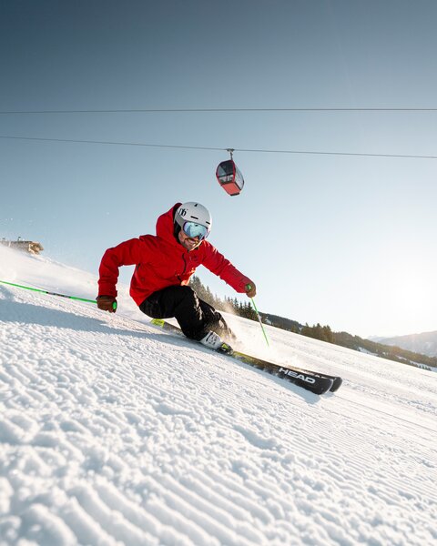 Skifahrer auf frisch präparierter Piste im Skigebiet Saalbach Hinterglemm